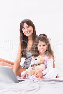 Happy mother and daughter with laptop