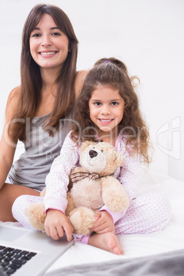 Smiling daughter and mother with laptop