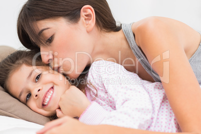 Mother kissing happy daughter on the cheek