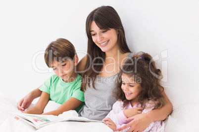 Mother with her children reading a storybook