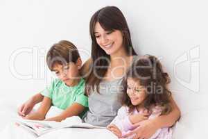 Mother with her children reading a storybook