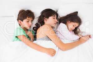 Mother asleep with her children