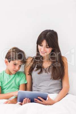 Happy mother using tablet pc with son