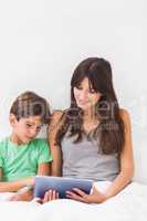 Happy mother using tablet pc with son