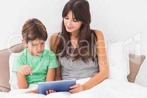Happy mother and son using tablet pc