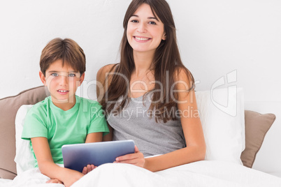 Happy mother and son using digital tablet