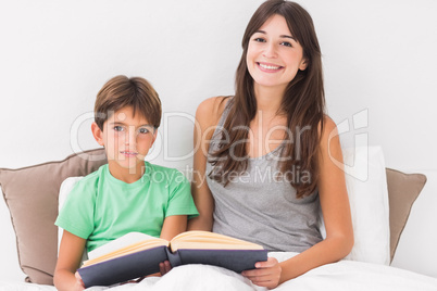 Happy mother and son reading book