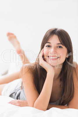 Smiling woman lying in bed