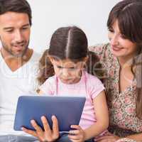 Parents watching daughter using tablet pc