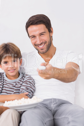 Smiling father and son watching tv