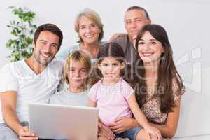 Happy family on couch using laptop
