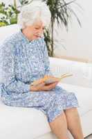 Elderly calm woman reading a old novel