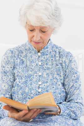 Elderly focused woman reading a old novel