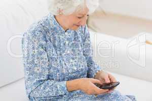 Elderly cheerful woman using a smartphone