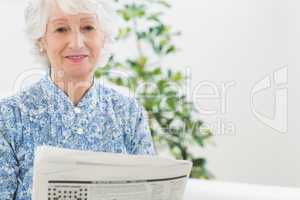 Elderly calm woman reading newspapers