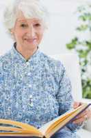 Elderly smiling woman with photo album