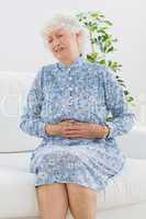 Elderly woman suffering with a belly pain