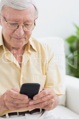 Focused elderly man using his smartphone