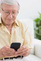 Focused elderly man using his smartphone