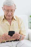 Calm elderly man using his smartphone