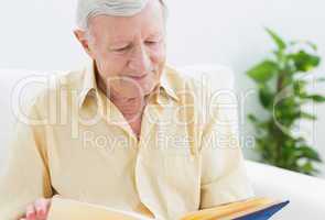 Elderly smiling man watching his album