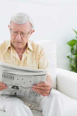 Focused elderly man reading the news