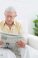 Focused elderly man reading the news