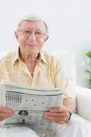 Smiling elderly man reading the news