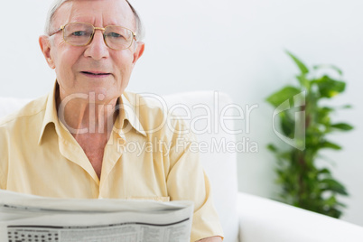 Cheerful elderly man reading the news