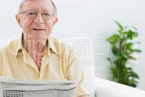 Cheerful elderly man reading the news