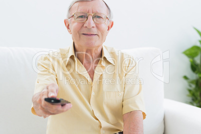 Smiling elderly man using the remote