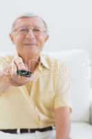Cheerful elderly man using the remote