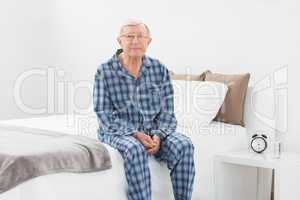 Aged man sitting on his bed