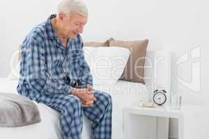 Elderly man sitting on the bed