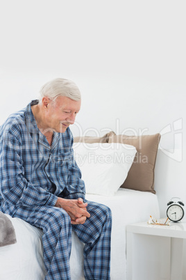 Calm elderly man sitting on the bed