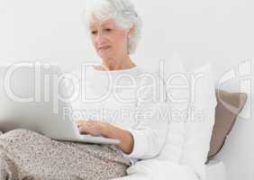 Elderly woman typing on her laptop