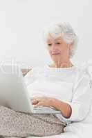 Aged woman typing on her laptop