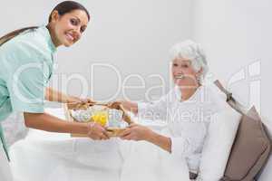 Home nurse giving a breakfast to the old woman