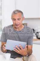 Focused man using his digital tablet