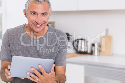 Happy man using his digital tablet