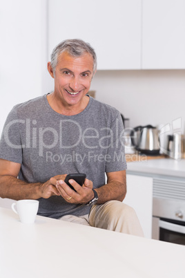 Smiling man touching his smartphone