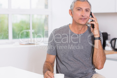 Man drinking while phoning