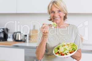 Smiling woman eating salad