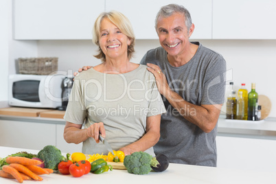 Happy couple cutting vegetables together