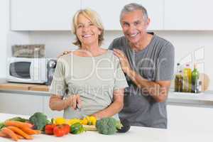 Happy couple cutting vegetables together