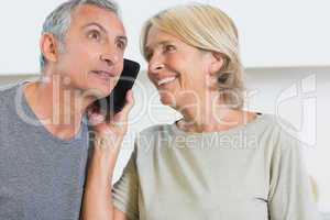 Happy mature couple listening a call together