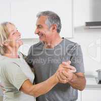 Smiling mature couple dancing together