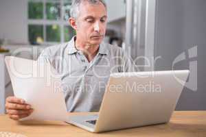 Calm mature man using his laptop