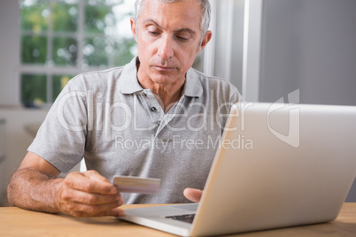 Thoughtful mature man using his laptop