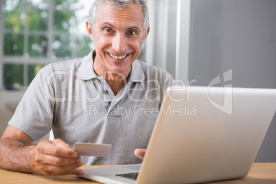 Smiling mature man using his laptop